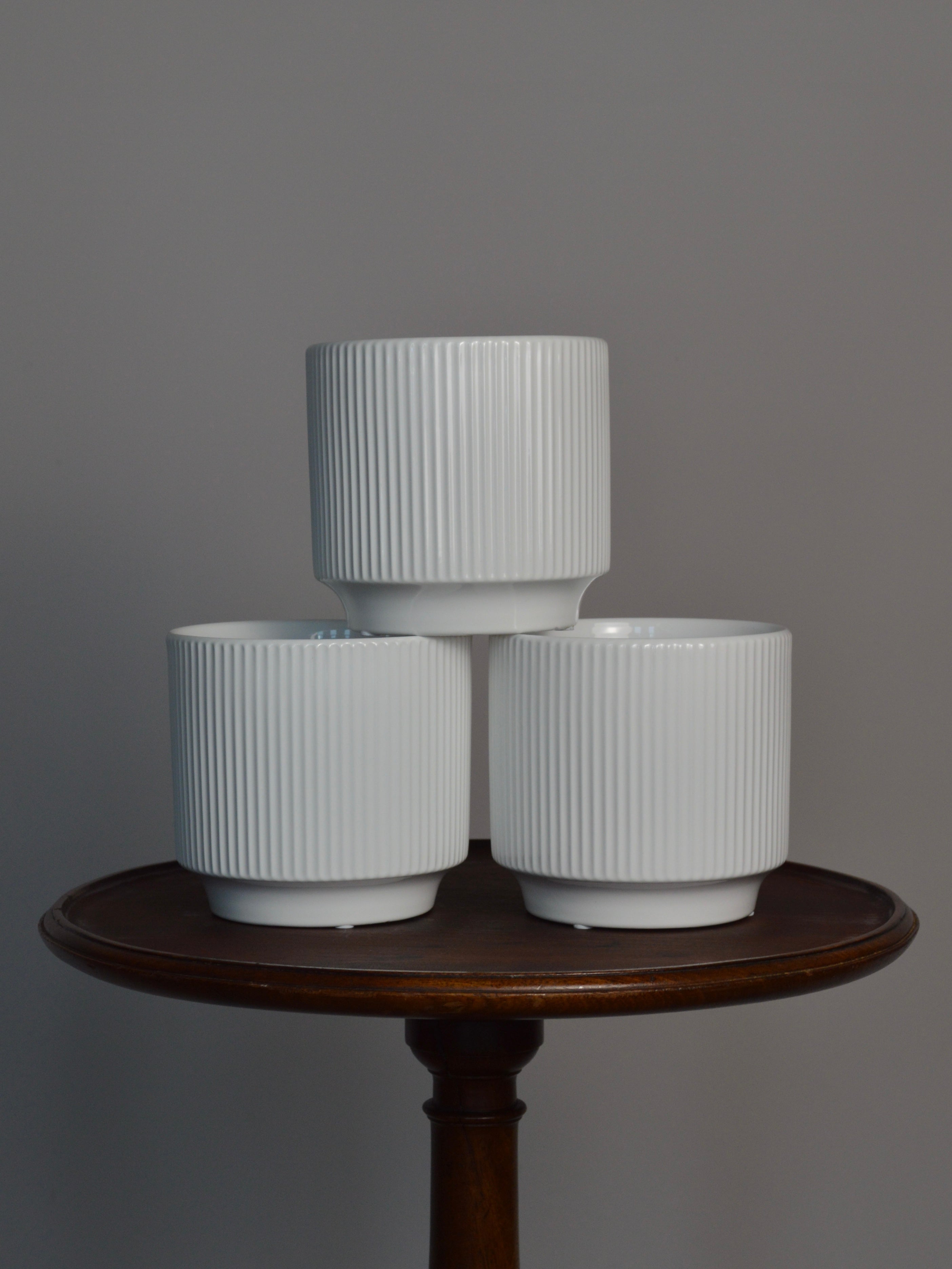 three white glazed ceramic plant pots